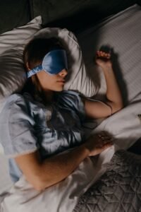 Woman peacefully sleeping on a cozy bed, promoting restful sleep.